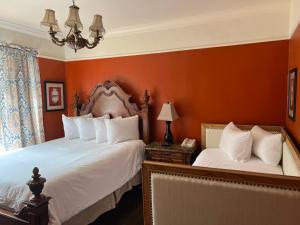 旧金山联合广场菲茨杰拉德酒店的卧室设有两张床铺和橙色墙壁
