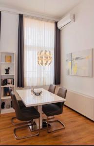 萨格勒布Main Square Dream Apartment的一间配备有白色桌椅的用餐室