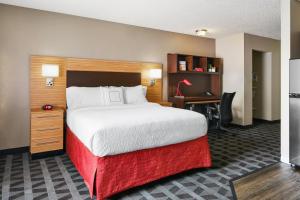 坦培亚利桑那坦佩米尔斯购物中心市镇广场酒店的酒店客房设有一张大床和一张书桌。