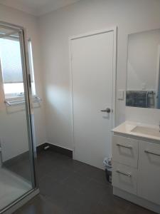 朱里恩湾Jurien Beachfront Chalets的带淋浴、盥洗盆和镜子的浴室