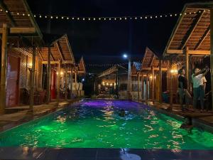 锡基霍尔The Bangka Beach Guesthouse的两人晚上站在游泳池里
