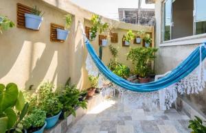 里约热内卢Espaço Acolhedor, Rio de Janeiro的庭院里种有盆栽植物,设有蓝色吊床