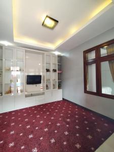 普禾加多Hotel Asri Baru的一间带电视和红地毯的客厅