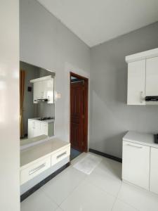 普禾加多Hotel Asri Baru的厨房配有白色橱柜和棕色门