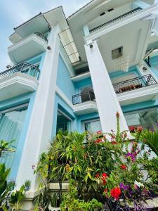 万荣VangVieng Crystal Boutique Hotel的前面有鲜花的蓝色建筑