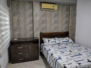 辛塞莱霍Casa España的一间卧室配有一张床和一个带四柱床的木制梳妆台。