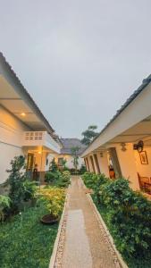 日惹CERIA HOTEL at Alun Alun Yogyakarta的植物繁茂的建筑庭院中的走道