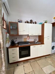 巴里Home Sweet Home rooms的厨房配有白色橱柜和炉灶烤箱。