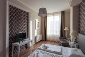 布达佩斯八角形房舍酒店的一间卧室配有一张床、一台电视和一把椅子