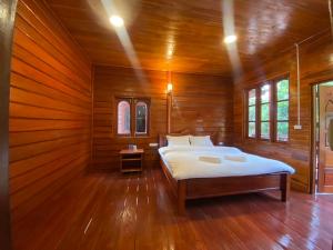 Ban OKonglor Cave Resort的木制客房内的一间卧室,配有一张床
