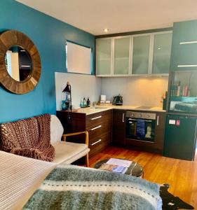 斯特拉恩Salt Box Hideaway的一间拥有蓝色墙壁的厨房、一张床和一张沙发