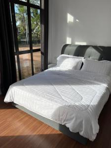 瓜拉丁加奴A’Casa Cottage的卧室内的一张带白色床单和枕头的床