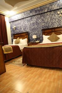 艾卜哈阿伯哈酒店的一间卧室设有两张床和蓝色的墙壁