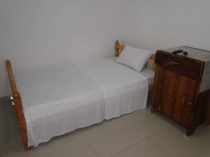 MutsamuduMEDINA HOTEL - Mutsamudu的一间卧室配有一张床和一个木制橱柜