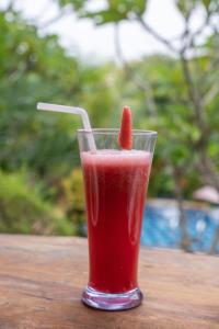 珀尼达岛Arunika Cottage的一杯红饮料,一杯水果