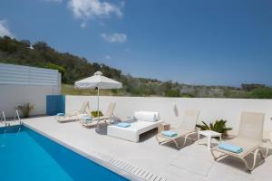 普罗塔拉斯Casa de Nicole的游泳池旁设有躺椅和遮阳伞的游泳池