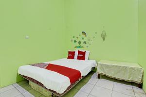 三宝垄OYO 92467 Cahyo Kost 1的一间卧室配有红色枕头的床
