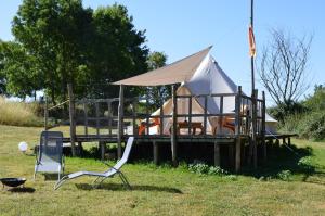 Curzay-sur-VonneCamping La Petite Houmée的码头上的帐篷,配有椅子和烧烤架