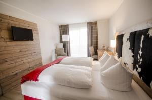 胡根尔舍姆赫施巴迪彻兰德霍夫旅馆的酒店客房设有一张大床和一台电视。