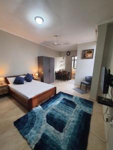 OyibiSpacious Holiday Let Wi-Fi & Private Amenities Oyibi的一间卧室配有一张床和蓝色地毯