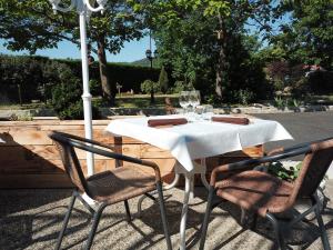 Vieille-BrioudeMaison Les Glycines的一张带两把椅子的白色桌子和一把伞