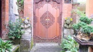 乌布Buana Ubud Inn的前面有两座雕像的红色门
