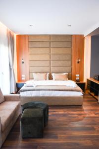 都拉斯Olivia's Hill Resort的一间卧室配有一张大床和一张沙发