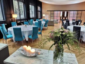 科沃布热格维嘉度假旅馆的用餐室配有白色的桌子和蓝色的椅子