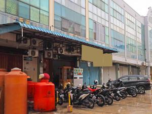 名古屋OYO 92451 Hasan House Syariah 2的停在大楼前的一排摩托车