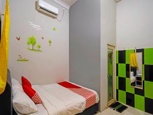 名古屋OYO 92451 Hasan House Syariah 2的一间卧室设有一张床和绿色白色的墙壁