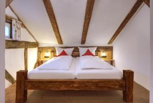 迪特福特Jurahaus Pröll Ottmaring的一间卧室配有一张带两个红色枕头的木床