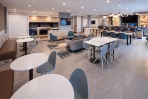 埃伦斯堡TownePlace Suites by Marriott Ellensburg的一间带桌椅的餐厅和一间酒吧