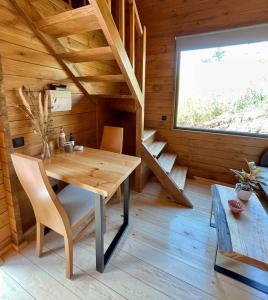 丰沙尔Mountain Eco Shelter 7的小木屋内的木制客房,配有桌椅