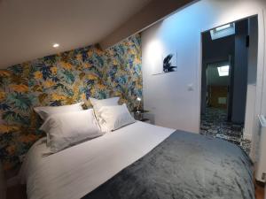 Saint-FonsStop Chez M Select Saga # Qualité # Confort # Simplicité的卧室配有一张白色大床和花卉壁纸