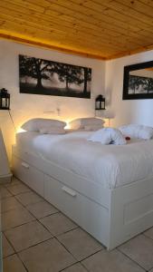里昂里昂古老公寓的卧室内的一张白色大床,拥有木制天花板