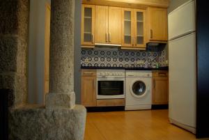 里瓦达维亚艾斯卡西塔斯度假屋的厨房配有木制橱柜和白色洗碗机。