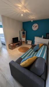 比斯卡罗斯海滩appartement T2 biscarosse plage的客厅配有沙发和墙上的时钟