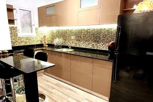 沙姆沙伊赫Luxury Getaway /Brand New 2BR /Wi-Fi /Full Kitchen的厨房配有柜台和黑冰箱。
