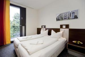 杜塞尔多夫杜塞尔多夫青年旅馆的窗户客房内的一张大白色床