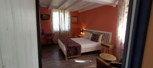 马尔凯Hôtel Bien-Être Aux Cyprès de Marquay的一间设有床铺的卧室,位于一个拥有橙色墙壁的房间