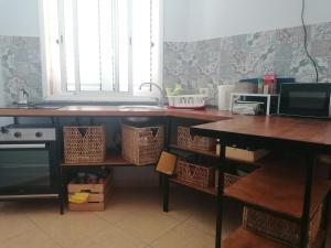 阿里纳加Amber House的厨房配有柜台和一张带篮子的桌子
