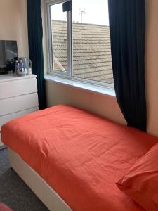 曼斯菲尔德Peaceful Place的一间卧室设有红色的床和窗户。