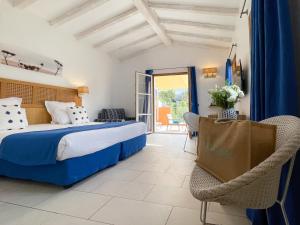 圣特罗佩乐莫伊拉格酒店的配有一张床和一把椅子的酒店客房