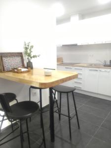 塞维利亚Sevilla Macarena apartamento 3 dormitorios的厨房配有木桌和四把椅子