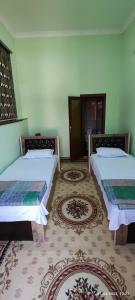 布哈拉Sezam的两张床铺,位于一间有两块地毯的房间
