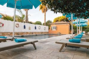 圣特罗佩乐莫伊拉格酒店的一个带蓝色躺椅和遮阳伞的游泳池