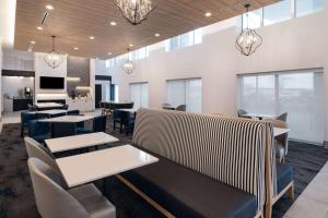 罗斯芒特La Quinta by Wyndham Chicago O'Hare Airport的用餐室配有桌椅和灯光