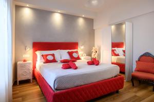 锡耶纳Lady Camollia Apartment的一间卧室配有一张带红色枕头的大床
