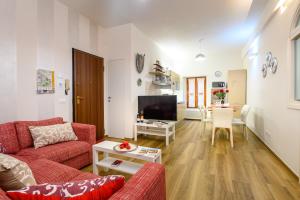 锡耶纳Lady Camollia Apartment的客厅配有2张红色沙发和1台电视