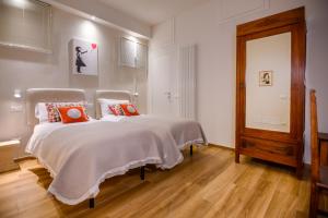锡耶纳Lady Camollia Apartment的一间卧室配有带橙色枕头的床